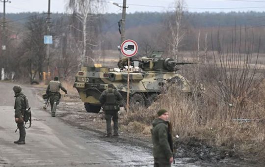 Ang mga servicemen ng Ukrainian ay nakatayo malapit sa isang armored personnel carrier BTR-3 sa hilagang-kanluran ng Kyiv.  — AFP