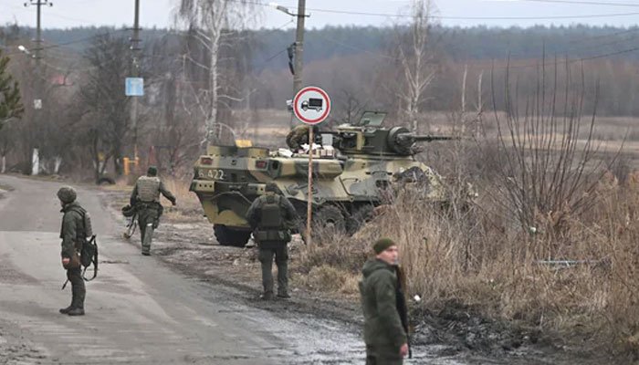 Ang mga servicemen ng Ukrainian ay nakatayo malapit sa isang armored personnel carrier BTR-3 sa hilagang-kanluran ng Kyiv.  — AFP