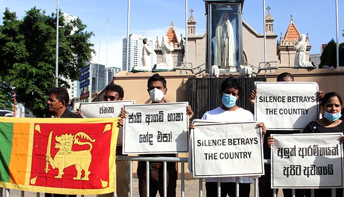 May hawak na mga plakard ang mga Katoliko habang nakikibahagi sila sa isang protesta sa labas ng simbahan sa Colombo noong Abril 9, 2022. — AFP