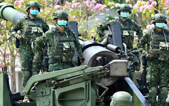 Nakatayo ang mga sundalong nakasuot ng face mask sa isang US-made M110A2 self-propelled howitzer sa pagbisita ni Taiwan President Tsai Ing-wens sa isang base militar noong Abril 2020. AFP/file