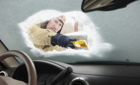 Caucasian na lalaking nag-scrape ng snow sa windshield ng kotse