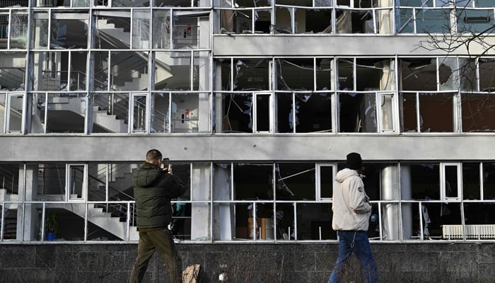 Tinitingnan ng mga bystanders ang isang gusaling pang-edukasyon sa Kyiv na nasira ng isang missile.  — AFP