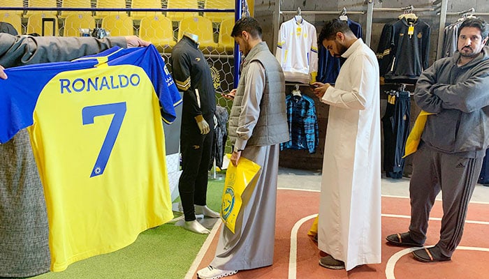 Isang fan ang may hawak na T-shirt na may pangalang Ronaldo at number 7, sa Saudi Al Nassr FC shop sa Saudi capital Ryadh, noong Disyembre 31, 2022. — AFP