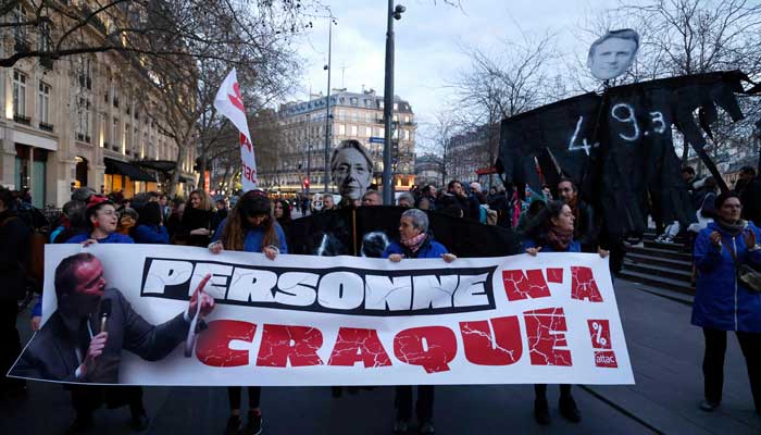 May hawak na banner at mga placard ang mga nagpoprotesta sa Place de la Republique sa isang demonstrasyon sa Paris noong Marso 21, 2023. — AFP