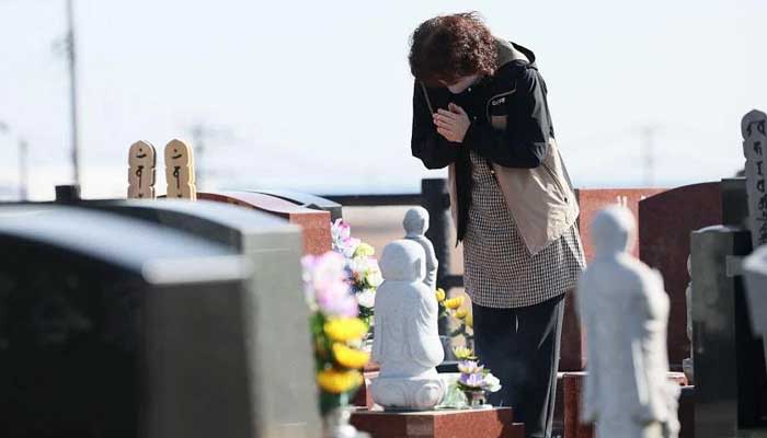 Isang nagdadalamhati ang nag-alay ng panalangin para sa mga biktima ng Great East Japan Earthquake sa isang sementeryo sa Namie, Japan, noong Marso 11, 2023. — AFP