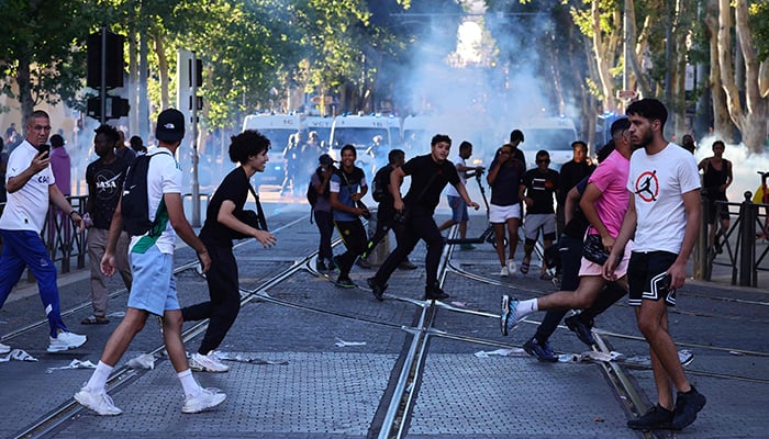 Tumatakbo ang mga nagpoprotesta mula sa inilunsad na mga tear gas canister habang nakikipagsagupaan sa mga pulis sa Marseille, southern France noong Hulyo 1, 2023. — AFP
